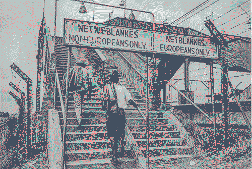 A segregated staircase at a train station with signs in the apartheid era.